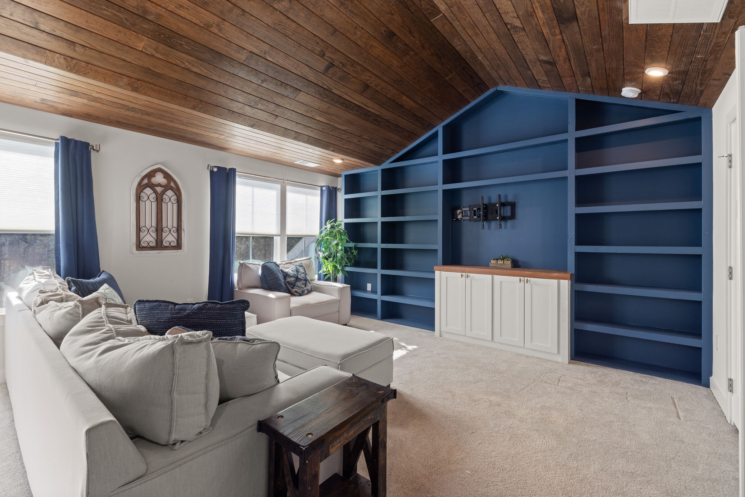 High-resolution real photograph of custom blue built-in shelving and a natural wood ceiling