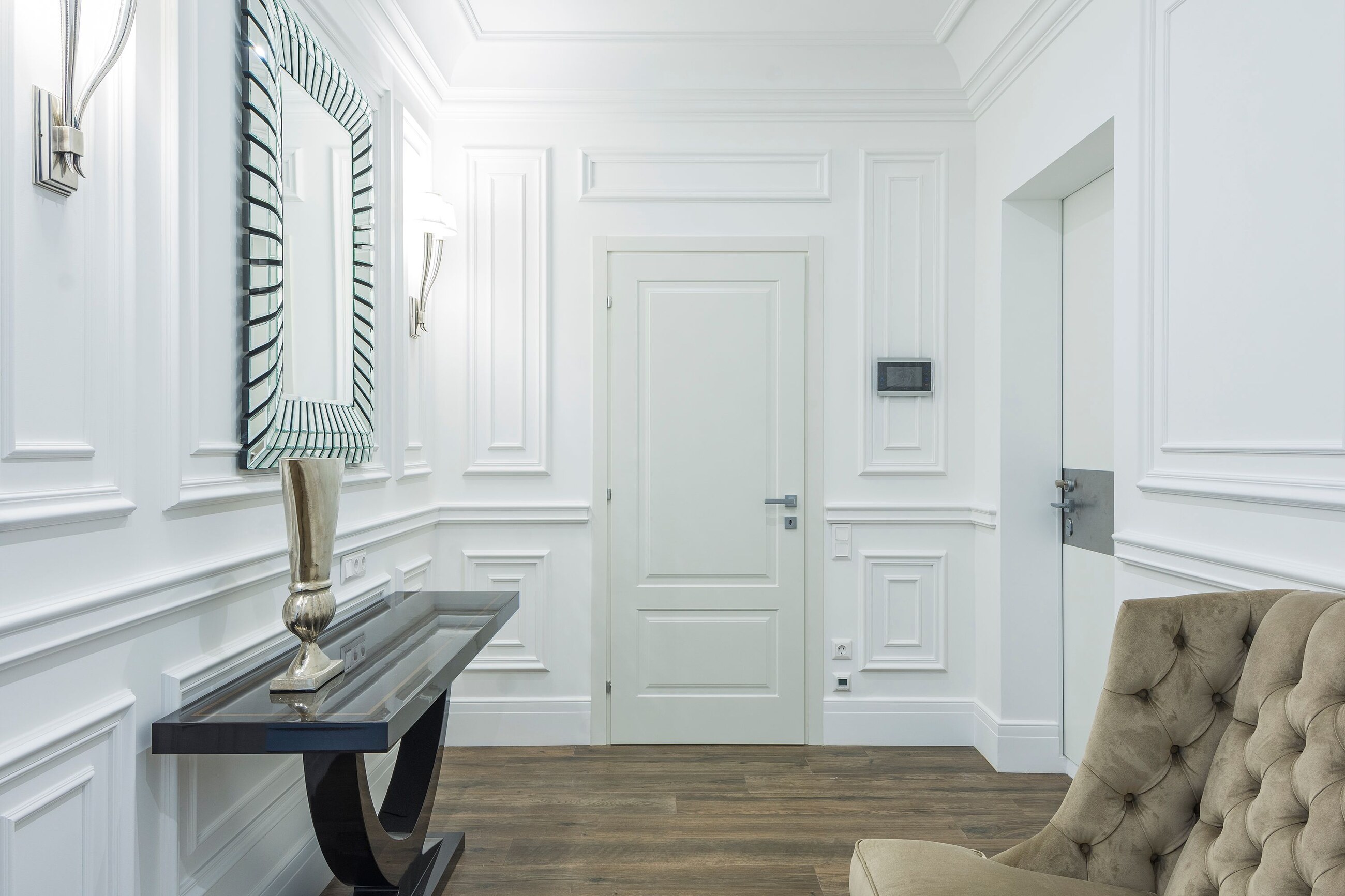 High-resolution real photograph of all-white picture-frame wall paneling and trim